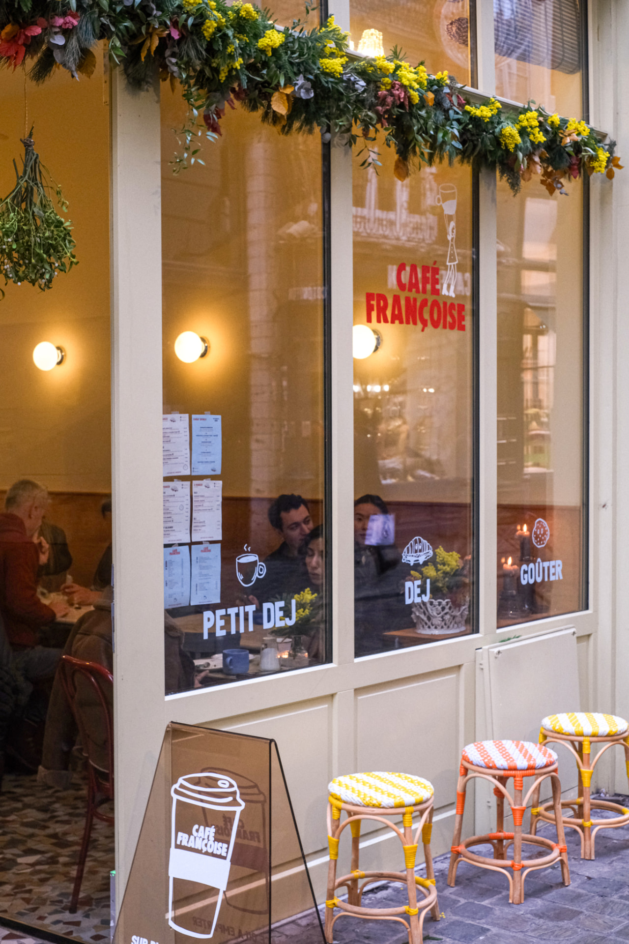 Devanture du Café Françoise à Lille, vitrine crème avec tabourets en rotin en terrasse