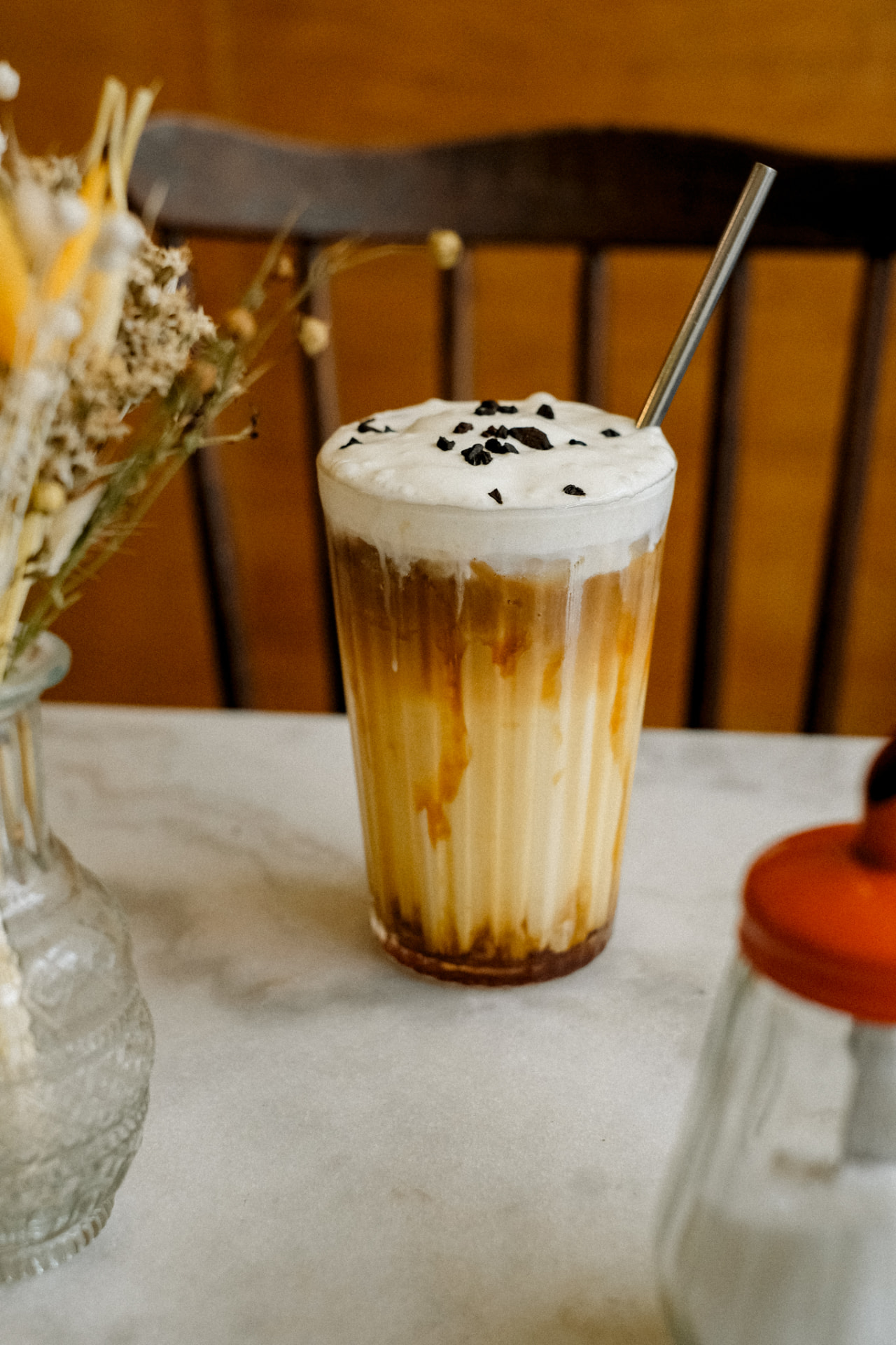 Boisson signature glacée à la chicorée avec crème chantilly sur une table en marbre